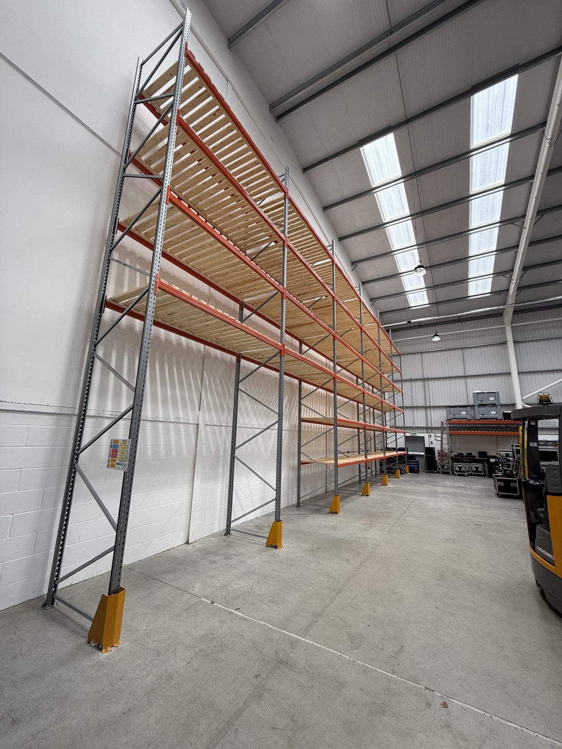 Pallet racking with visible frame bracing, load notice and yellow upright protectors